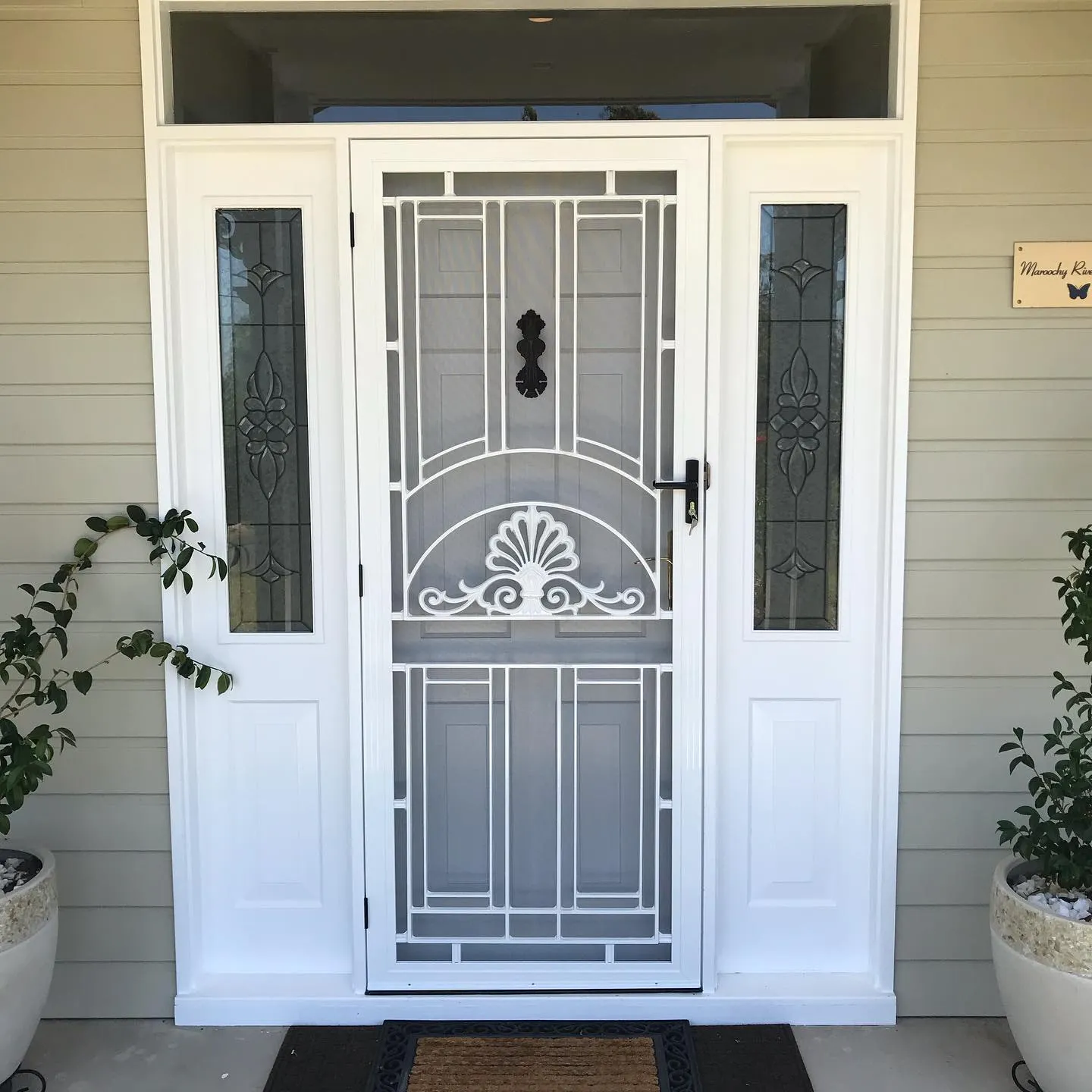 Stainless mesh security screen door on the front entry of a coastal home